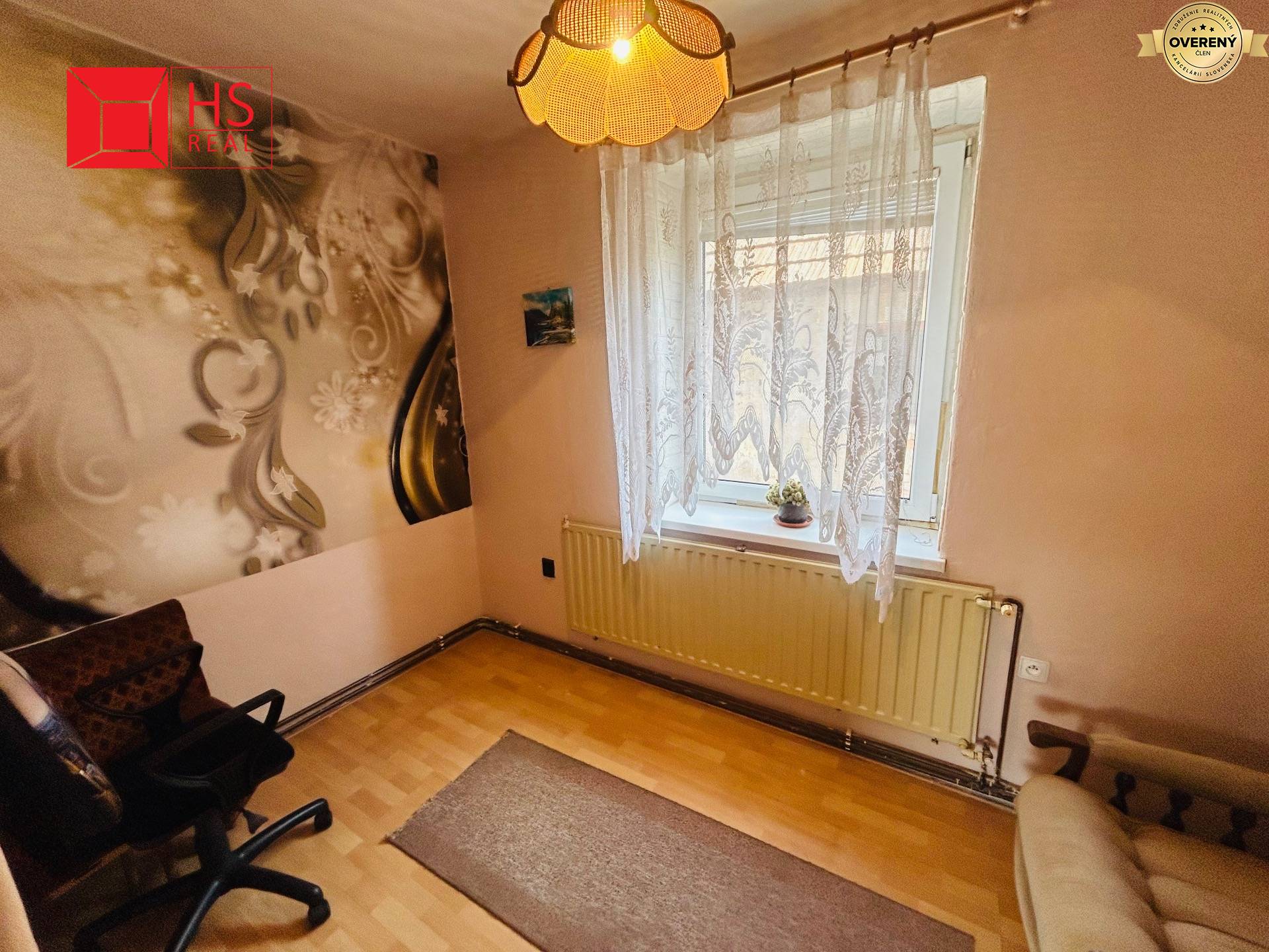 Izba v rodinnom dome s ornamentálnou stenou a podlahou s dreveným dekorom.