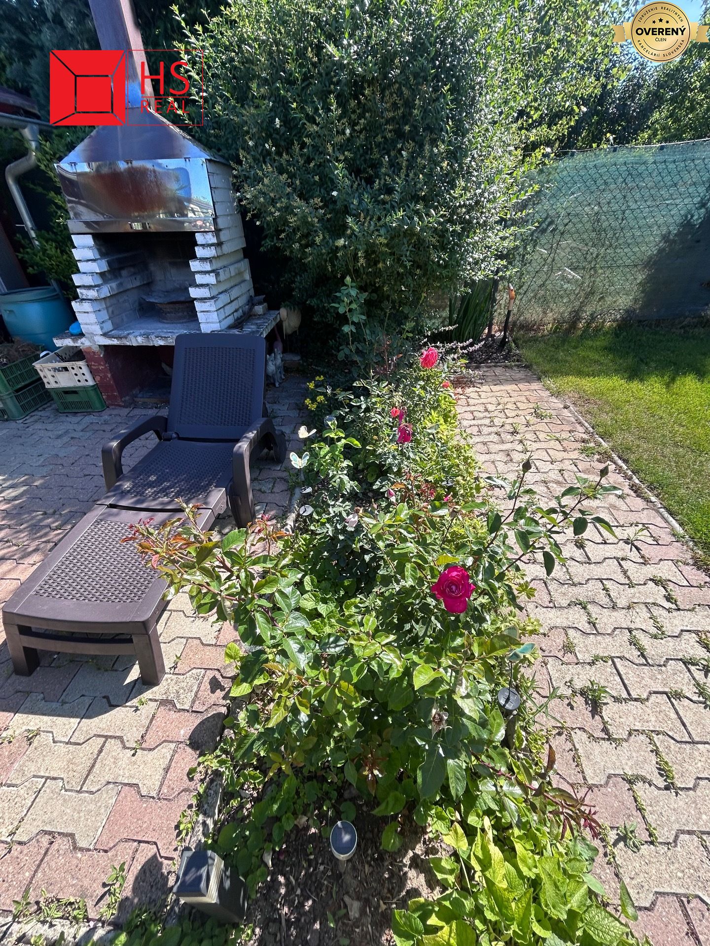 Dvor chaty na Tekvičnom Poli v Nových Zámkoch s ležadlom a kvetmi.