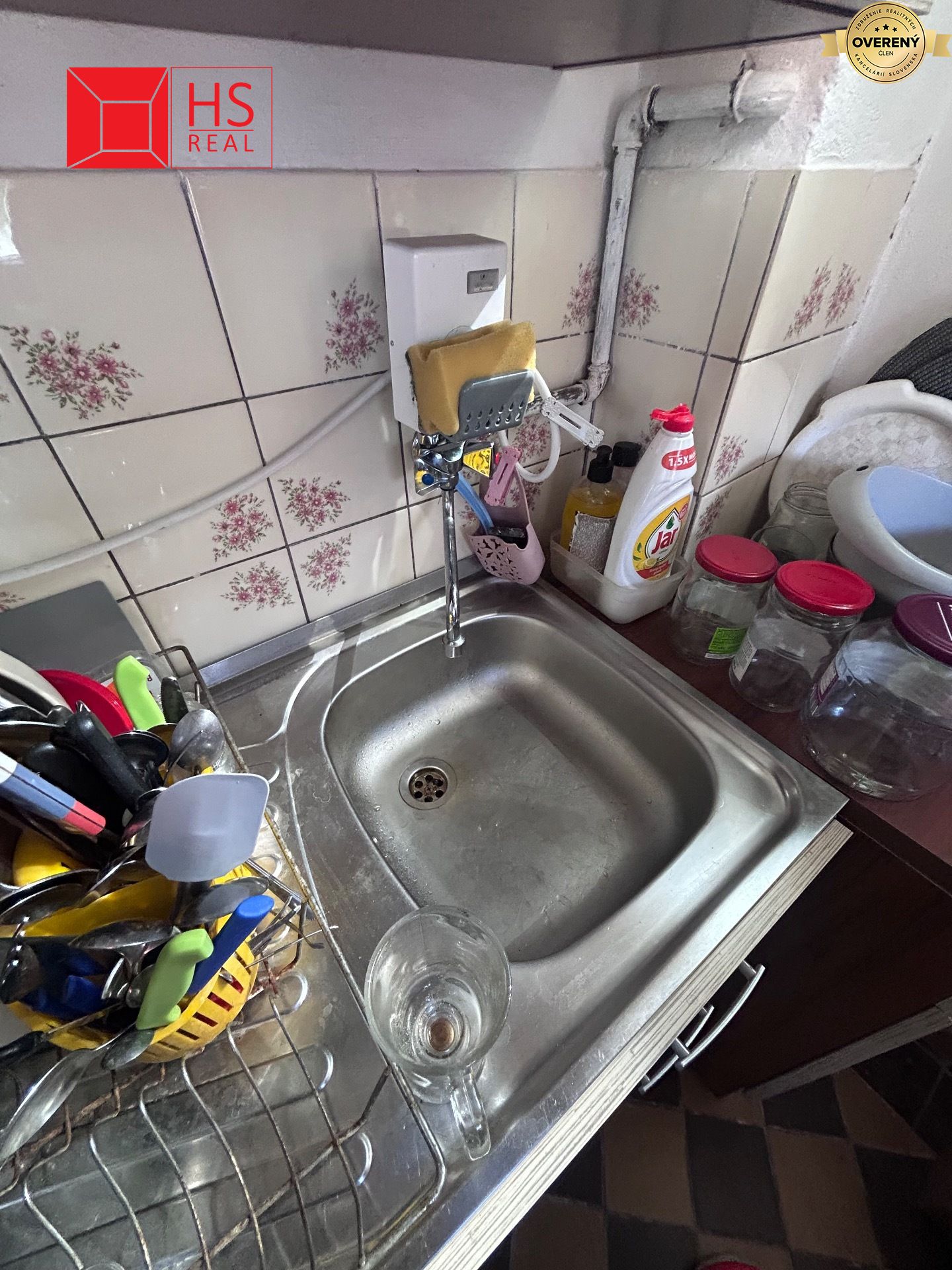 Kuchynský kút v chate s drezom a riadom na odkvapkávači.