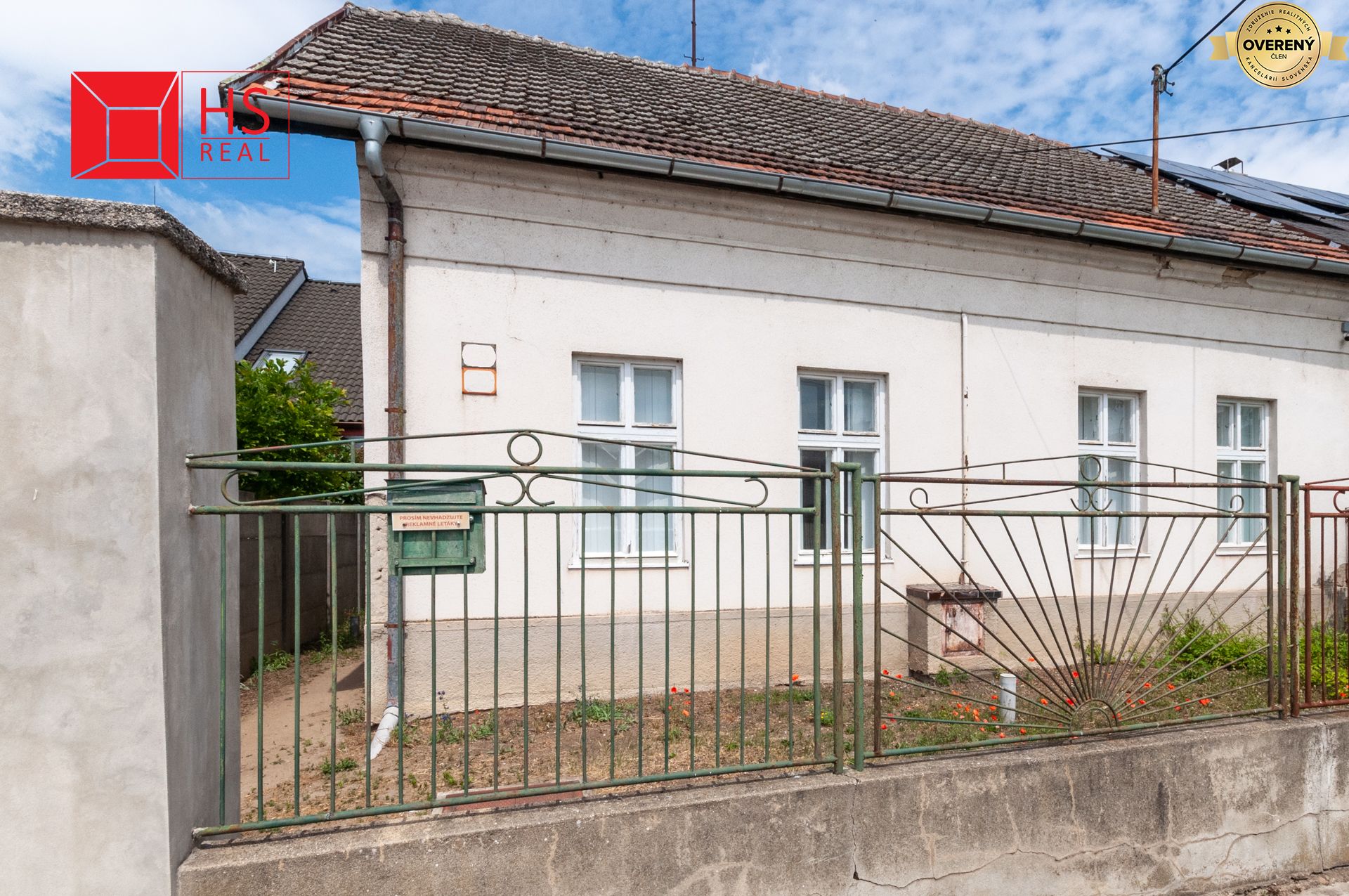 Rodinný dom na Dojstojevského ulici v Nových Zámkoch so staršou fasádou a predzáhradkou.